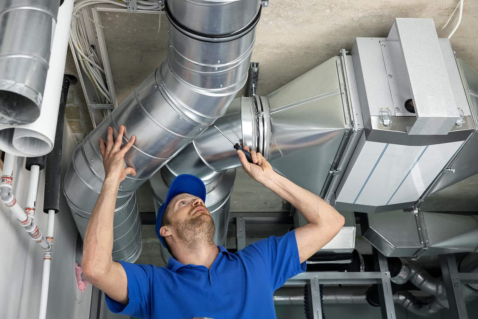 HVAC technician inspecting and repairing air ducts in Windsor