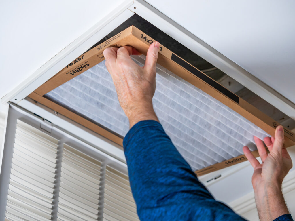 HVAC technician replacing a home air filter in Windsor