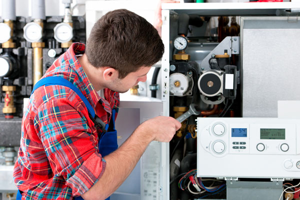 Heating technician repairing boiler controls in Windsor