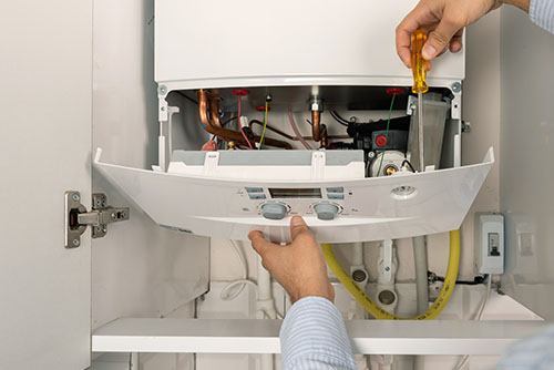 Heating technician repairing a residential boiler in Windsor