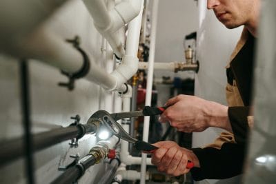 Technician inspecting commercial plumbing pipes in Windsor