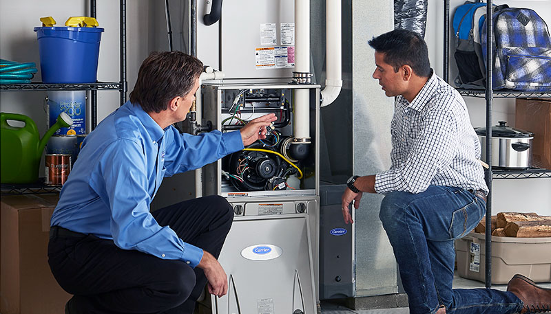 Technician evaluating a furnace for repair or replacement in Windsor