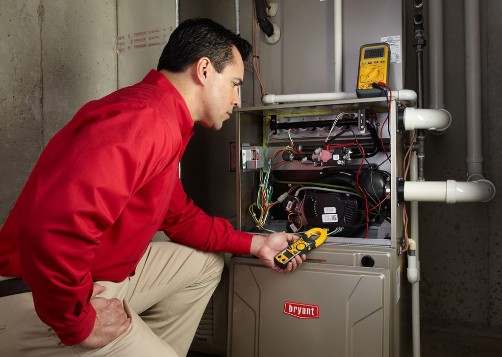 Heating technician diagnosing a furnace repair in Windsor