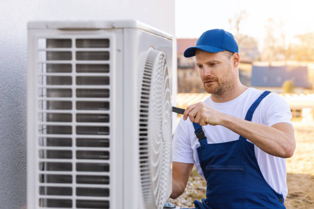 HVAC technician servicing an outdoor air conditioner in Windsor