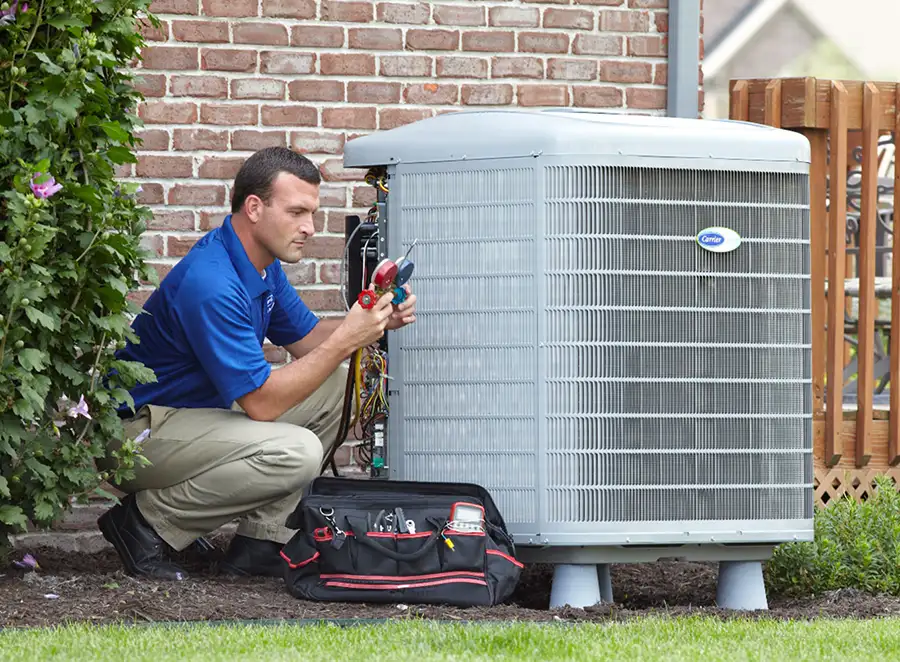 HVAC technician inspecting an outdoor AC unit in Windsor