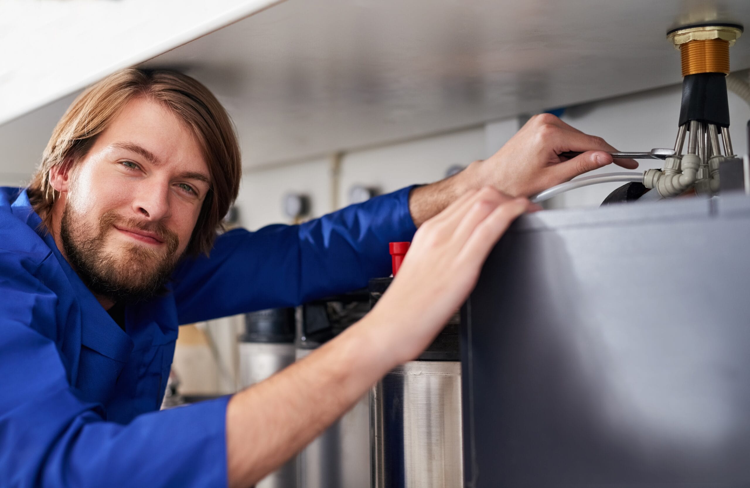 Technician servicing a residential water heater tank in Windsor