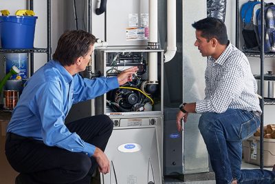 Technician evaluating a furnace for repair or replacement in Windsor