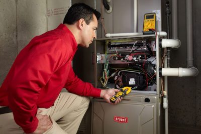 Heating technician diagnosing a furnace repair in Windsor